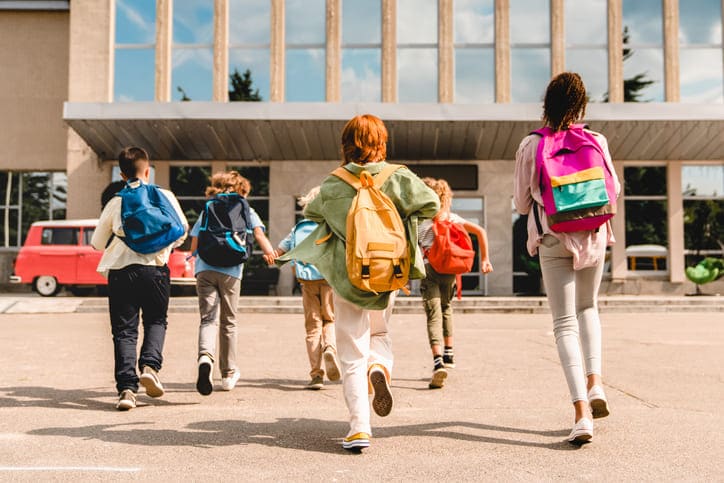 Schüler rennen auf ein Gebäude zu