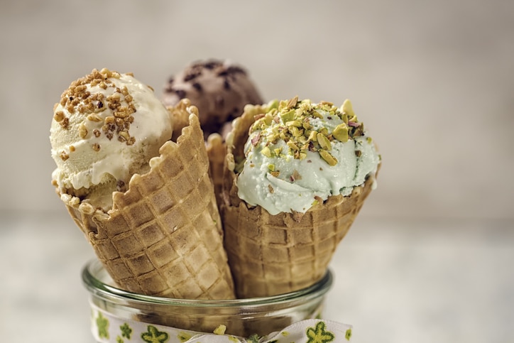 drei verschiedene Eissorten im Becher mit Streuseln oben drauf. Vanille-, Schokolade- und Pistazien-Eiscreme